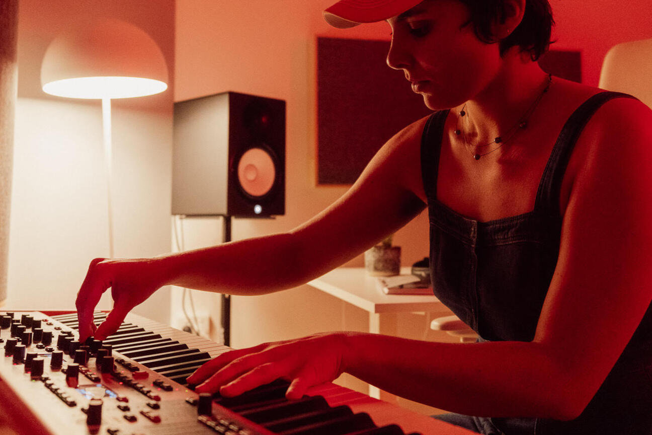Prudns sitting in her music studio looking at the camera. She looks serious.